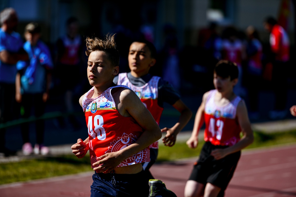 Niños corriendo en pista de atletismo