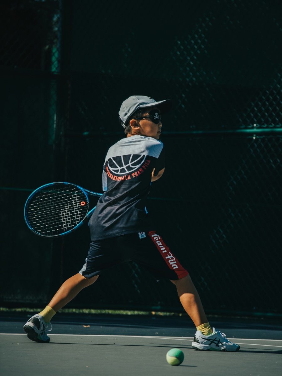 Niño jugando al tenis