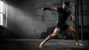 Atleta de deportes de combate en un golpe explosivo en el gimnasio: transferencia de fuerza del suelo al puño