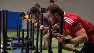 Opositores empujando trineo cargado con discos en el entrenamiento de las pruebas físicas de bomberos en S4S
